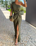 Woman wearing a green one-shoulder satin maxi dress with twist-knot waist and front slit