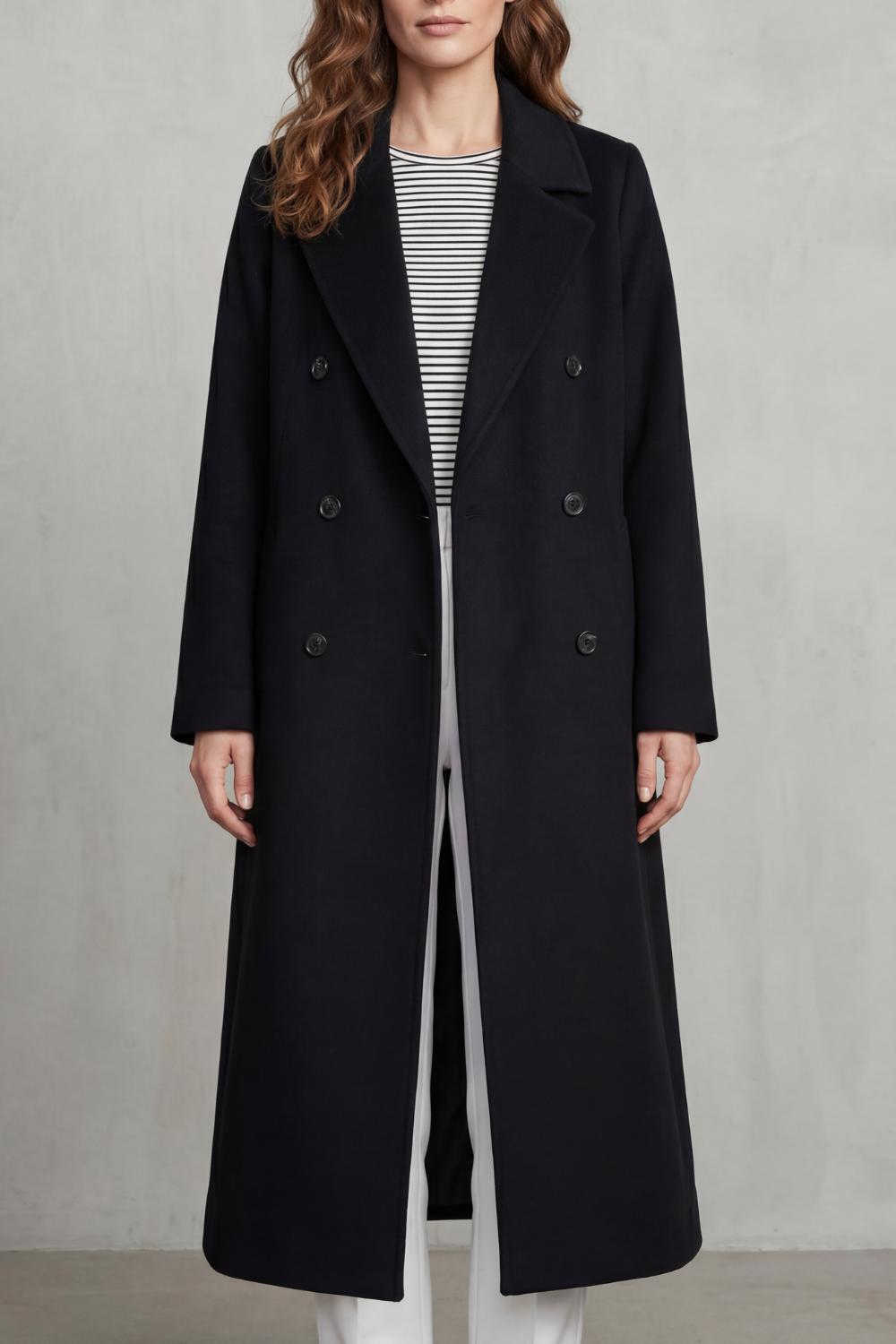 Woman wearing a long black double-breasted coat with notch lapels and six buttons