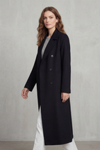 Woman wearing a long black double-breasted coat with notch lapels and six buttons - view 3