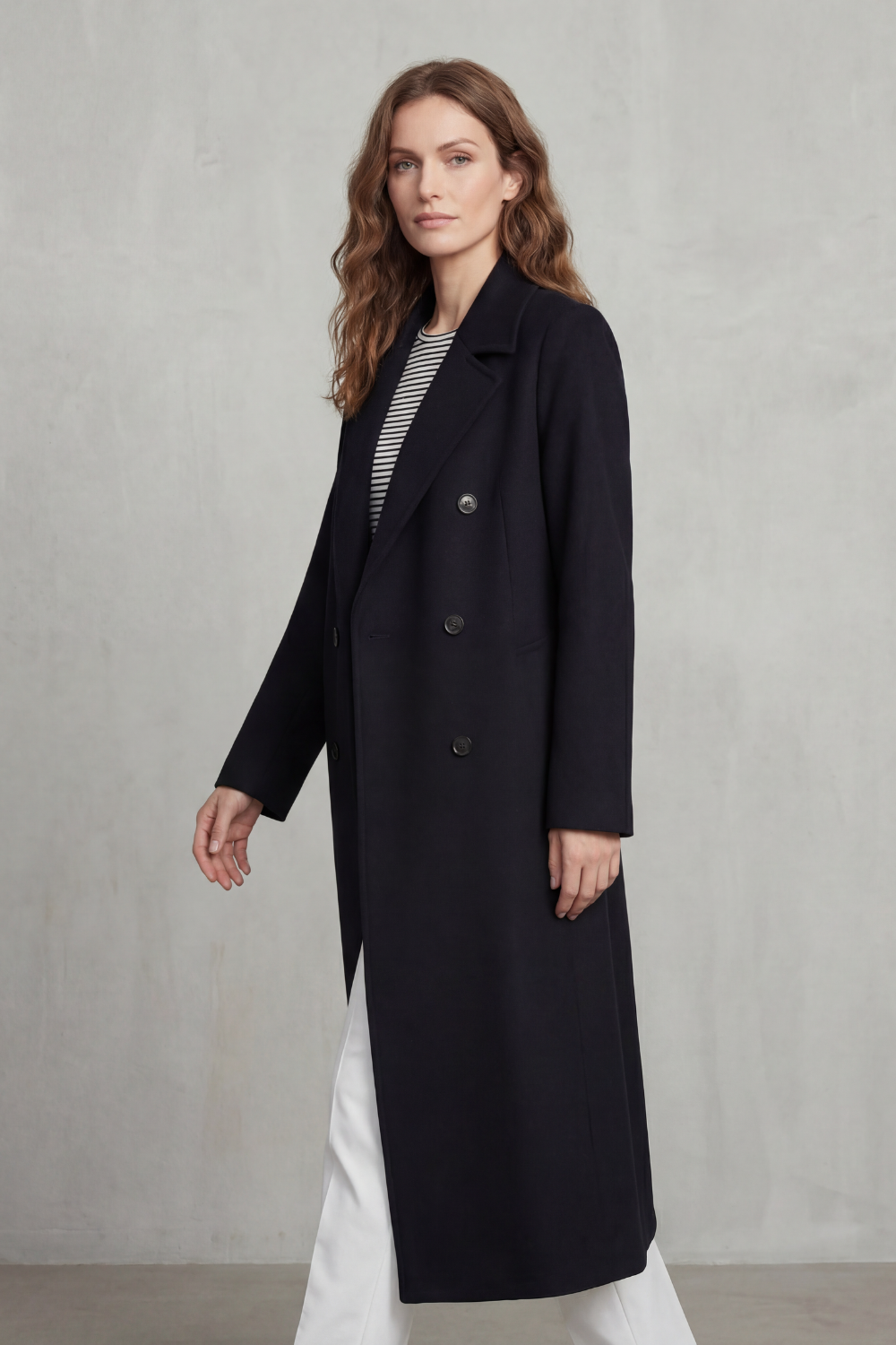 Woman wearing a long black double-breasted coat with notch lapels and six buttons - view 3