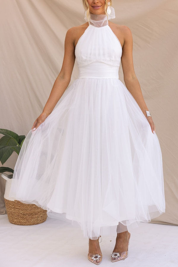 Woman wearing a sleeveless tulle halter midi dress with ruched bodice and full skirt - view 5