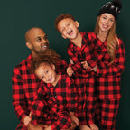 Family wearing matching red and black buffalo plaid Christmas pajamas