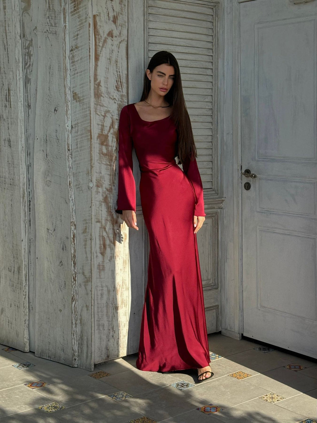 Woman wearing a fitted satin long sleeve maxi dress with bell sleeves and wide scoop neckline - view 10