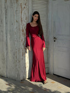 Woman wearing a fitted satin long sleeve maxi dress with bell sleeves and wide scoop neckline - view 10