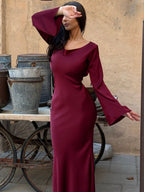 Woman wearing a fitted satin long sleeve maxi dress with bell sleeves and wide scoop neckline - view 19