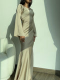 Woman wearing a fitted satin long sleeve maxi dress with bell sleeves and wide scoop neckline - view 4