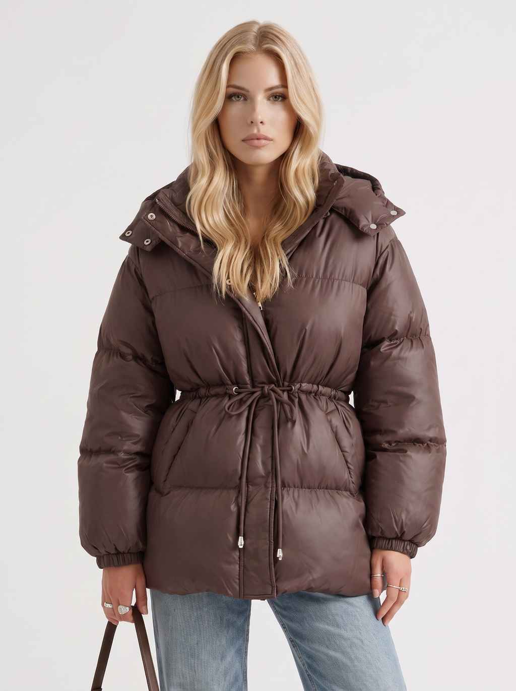 Woman in a brown quilted hooded puffer jacket with drawstring waist