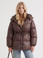 Woman in a brown quilted hooded puffer jacket with drawstring waist