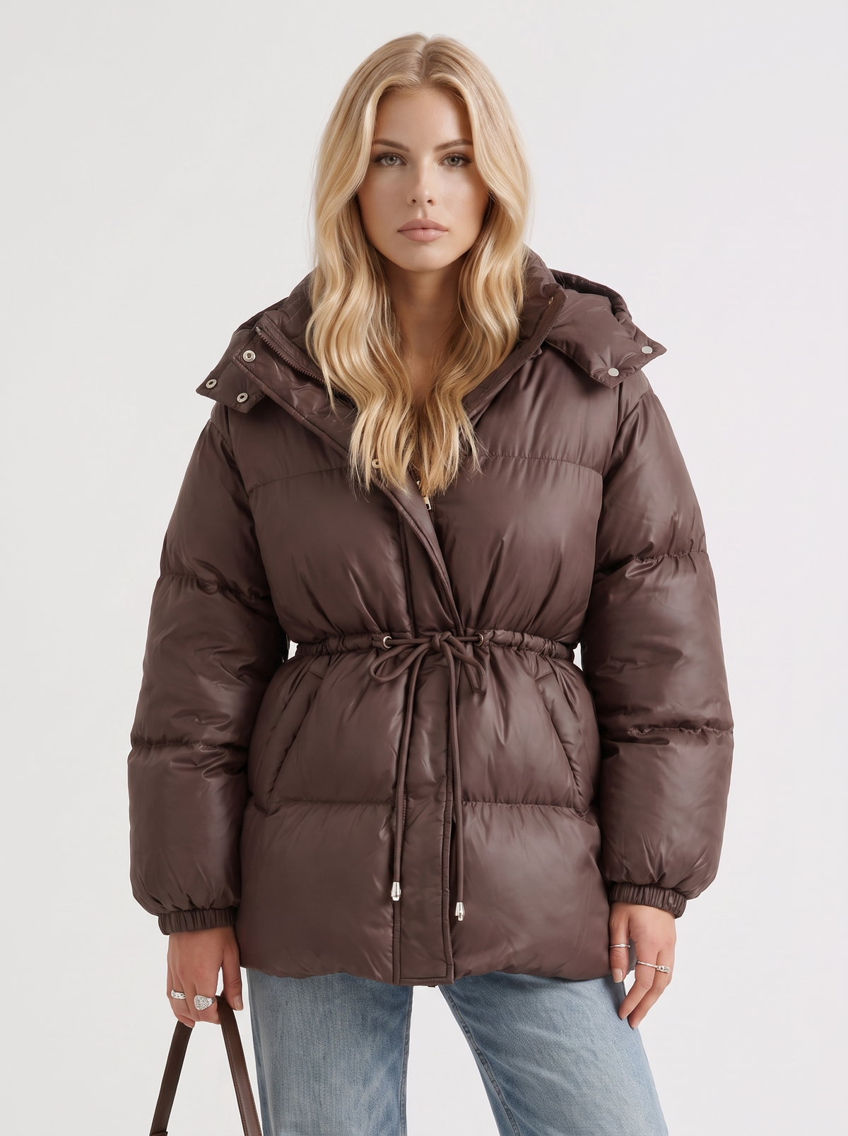 Woman in a brown quilted hooded puffer jacket with drawstring waist