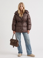 Woman in a brown quilted hooded puffer jacket with drawstring waist - view 2