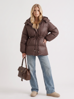 Woman in a brown quilted hooded puffer jacket with drawstring waist - view 3
