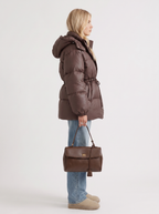 Woman in a brown quilted hooded puffer jacket with drawstring waist - view 4