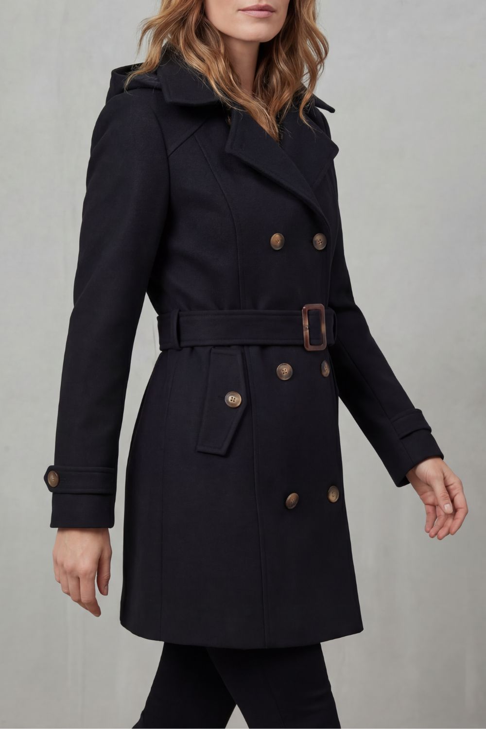 Woman wearing a black hooded double-breasted belted trench coat - view 3