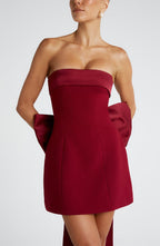 Woman wearing a white strapless A-line mini dress with an oversized back bow and long trailing tails - view 10