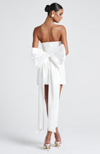 Woman wearing a white strapless A-line mini dress with an oversized back bow and long trailing tails - view 6
