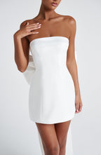 Woman wearing a white strapless A-line mini dress with an oversized back bow and long trailing tails - view 7