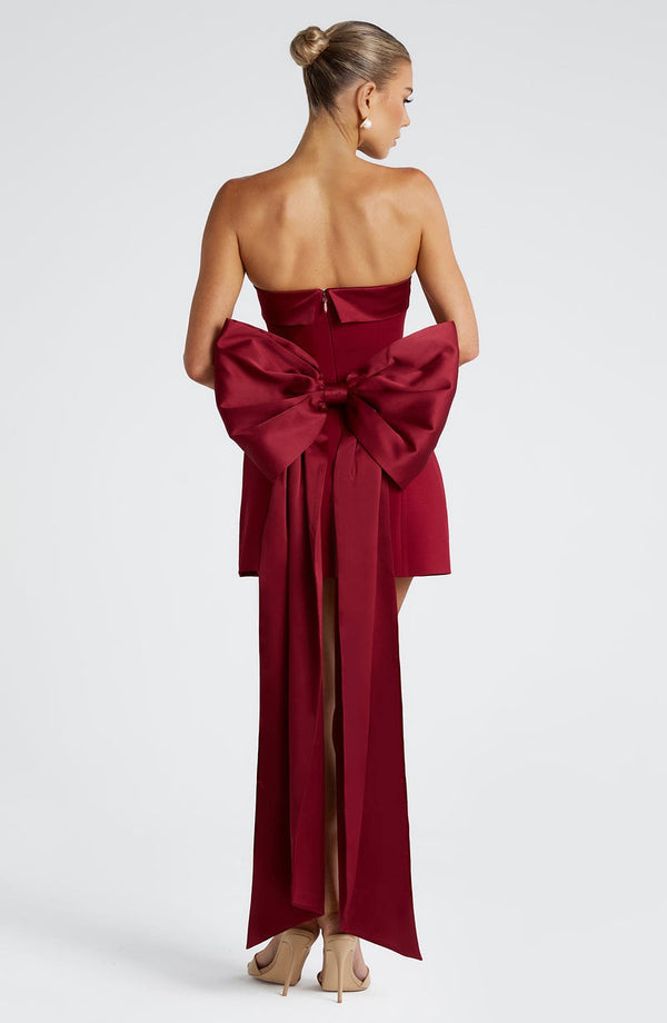 Woman wearing a white strapless A-line mini dress with an oversized back bow and long trailing tails - view 8