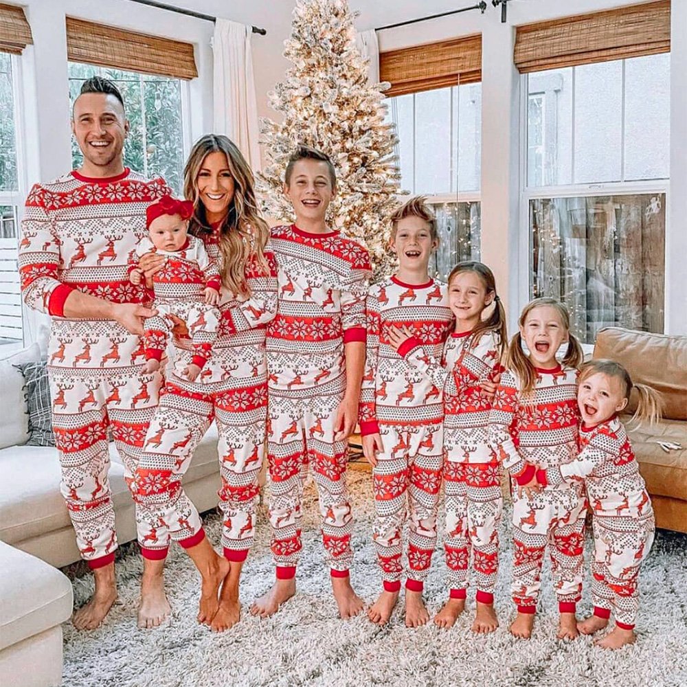 Family wearing matching red and white reindeer and snowflake print Christmas pajamas - view 13