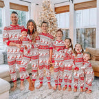 Family wearing matching red and white reindeer and snowflake print Christmas pajamas - view 13