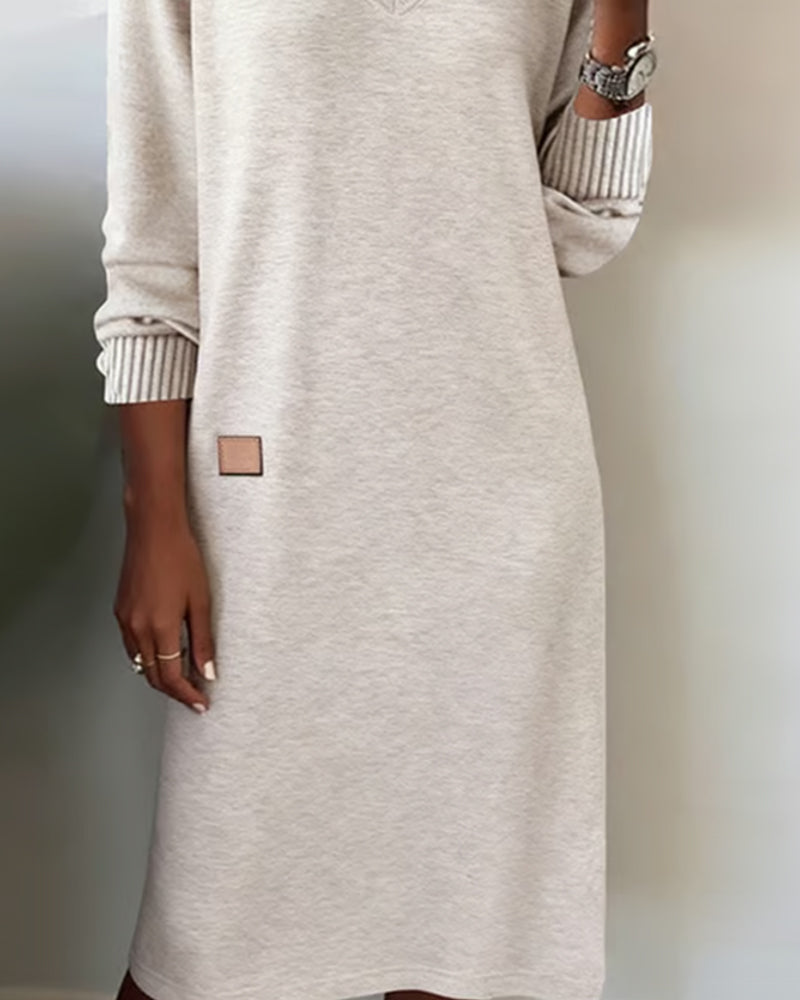 Woman wearing a V-neck long sleeve midi sweater dress with ribbed cuffs and a small patch detail - view 2