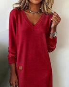 Woman wearing a V-neck long sleeve midi sweater dress with ribbed cuffs and a small patch detail - view 5