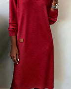 Woman wearing a V-neck long sleeve midi sweater dress with ribbed cuffs and a small patch detail - view 6