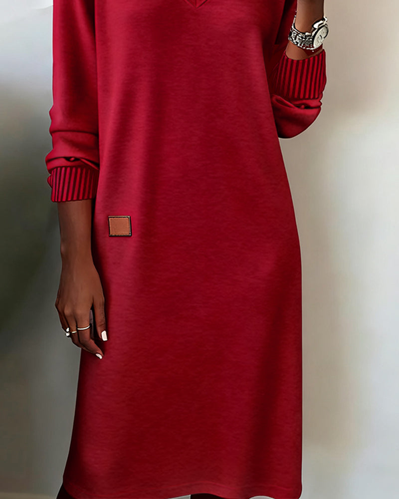 Woman wearing a V-neck long sleeve midi sweater dress with ribbed cuffs and a small patch detail - view 6