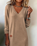 Woman wearing a V-neck long sleeve midi sweater dress with ribbed cuffs and a small patch detail - view 8