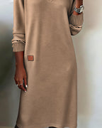 Woman wearing a V-neck long sleeve midi sweater dress with ribbed cuffs and a small patch detail - view 9