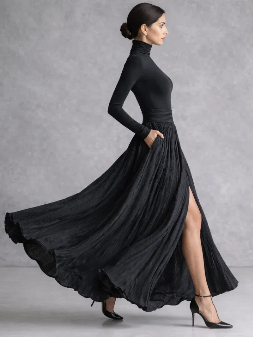 Woman in a black pleated turtleneck maxi dress with long sleeves and front slit - view 2