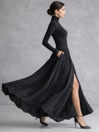 Woman in a black pleated turtleneck maxi dress with long sleeves and front slit - view 2