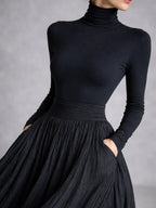 Woman in a black pleated turtleneck maxi dress with long sleeves and front slit - view 3