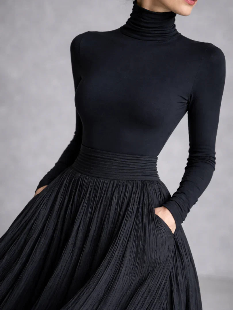 Woman in a black pleated turtleneck maxi dress with long sleeves and front slit - view 3
