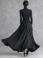Woman in a black pleated turtleneck maxi dress with long sleeves and front slit - view 4