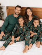 Family wearing matching green safari animal print Christmas pajamas
