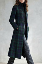 Woman wearing a long navy and green plaid stand collar coat with metal buttons - view 3