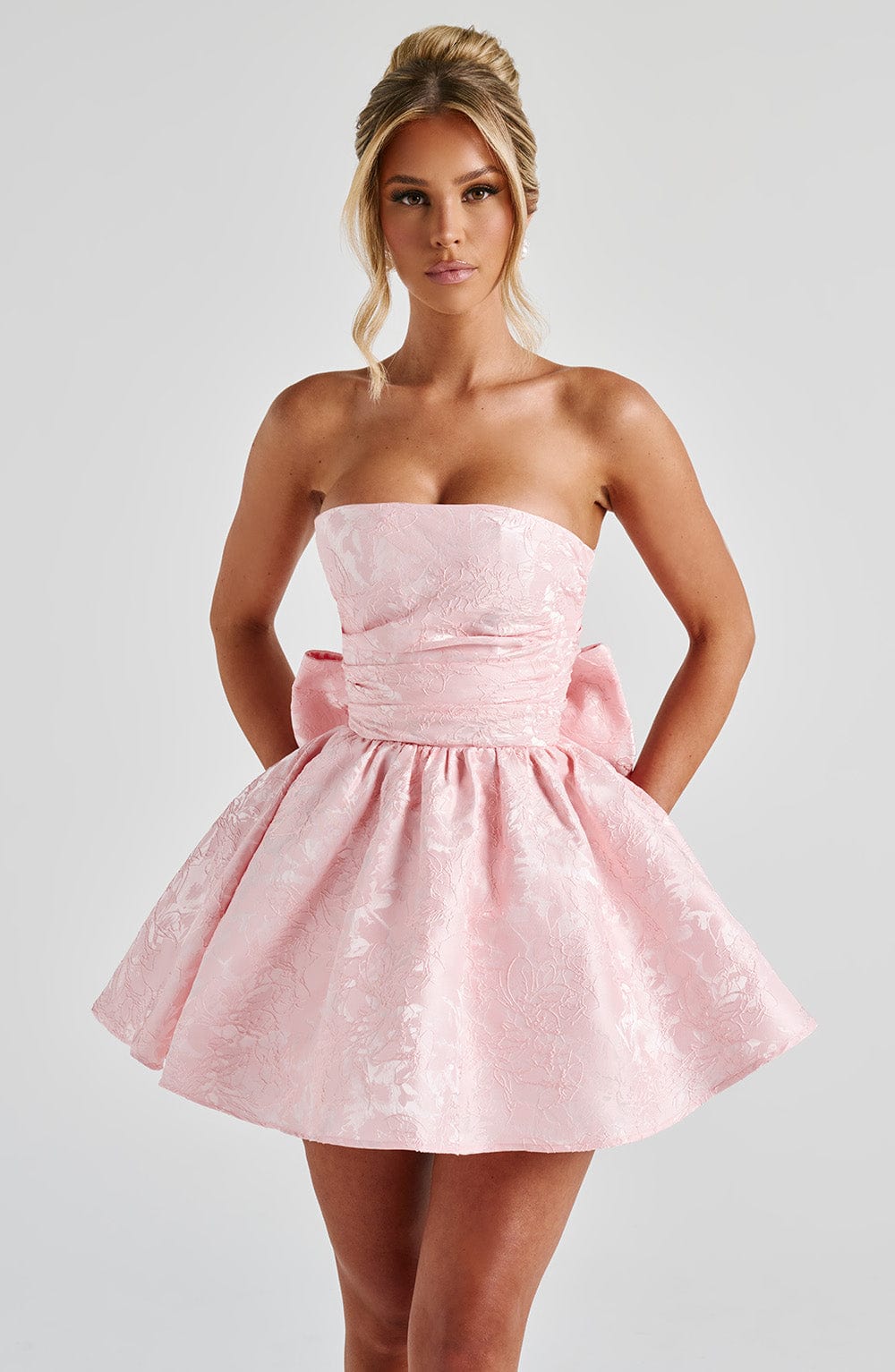 Pink floral jacquard strapless mini dress with oversized back bow and lace-up back