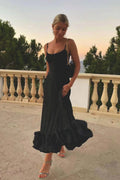 Woman wearing a spaghetti strap midi dress with fitted scoop-neck bodice and full ruffle hem