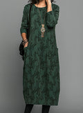 Woman wearing a green leaf jacquard long sleeve midi dress with patch pockets and crew neck