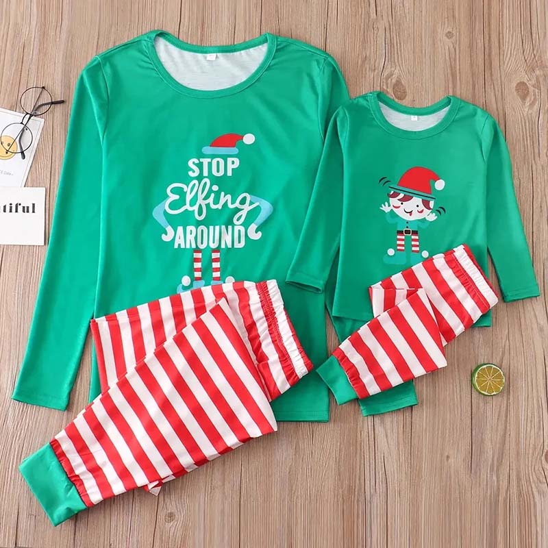 Family in matching green elf graphic tops and red and white striped Christmas pajama pants - view 7