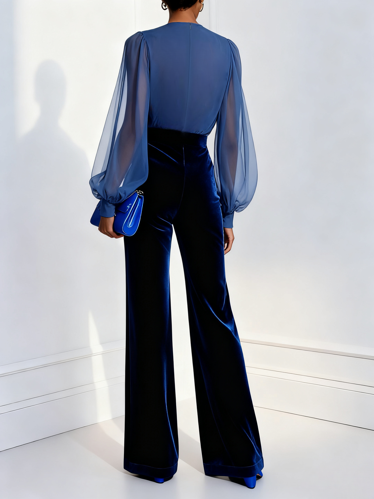 Model in a blue velvet evening jumpsuit with wide legs and sheer balloon sleeves - view 2