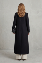 Woman wearing a long black double-breasted coat with notched lapels - view 4