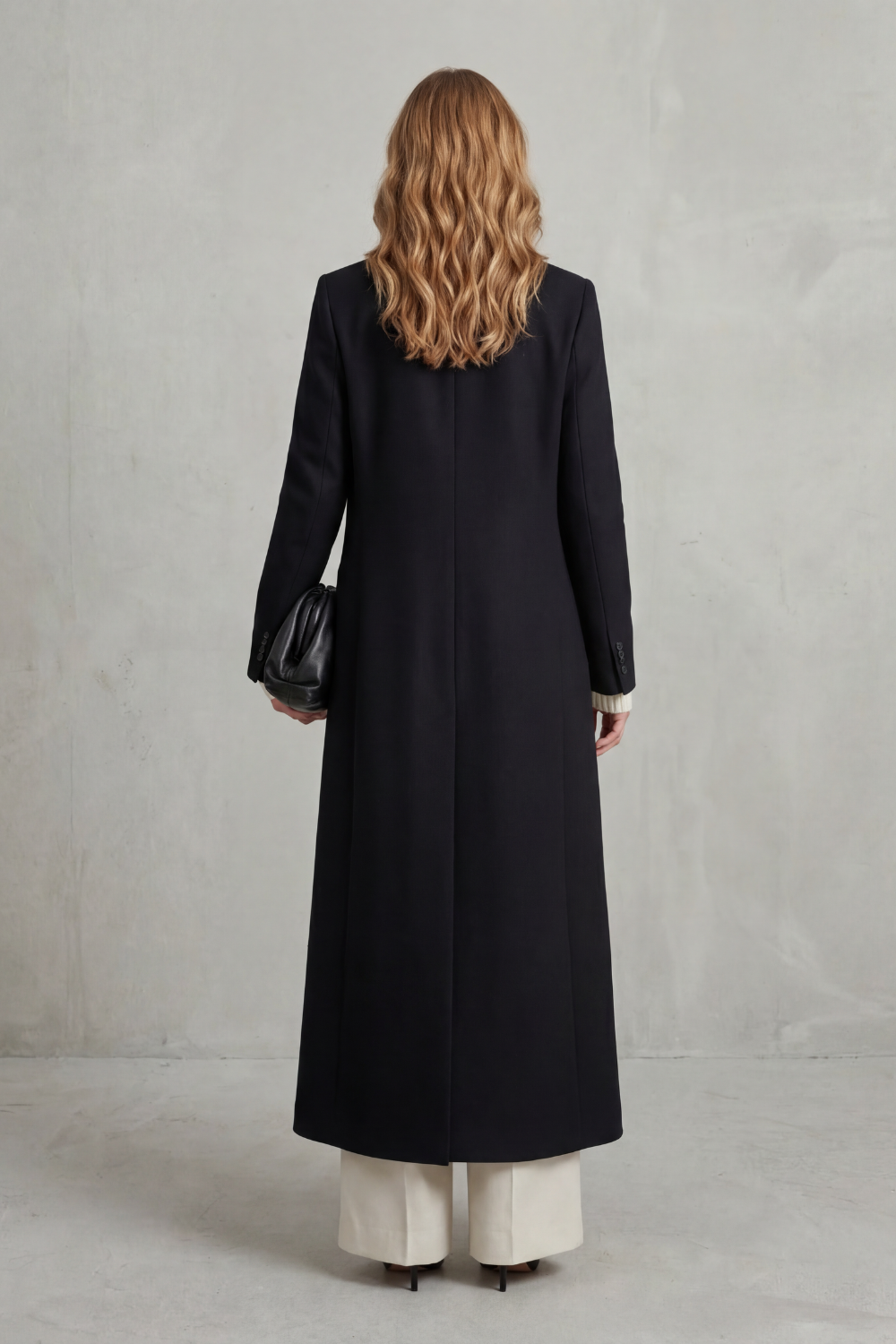Woman wearing a long black double-breasted coat with notched lapels - view 4