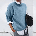 Oversized knit sweater with crew neck and dropped shoulders, layered over a white shirt