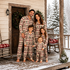 Family wearing matching cream Christmas pajamas with reindeer and tree print