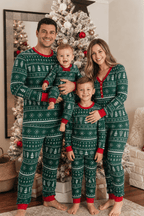 Matching family Christmas pajamas in green with white tree and snowflake print and red cuffs
