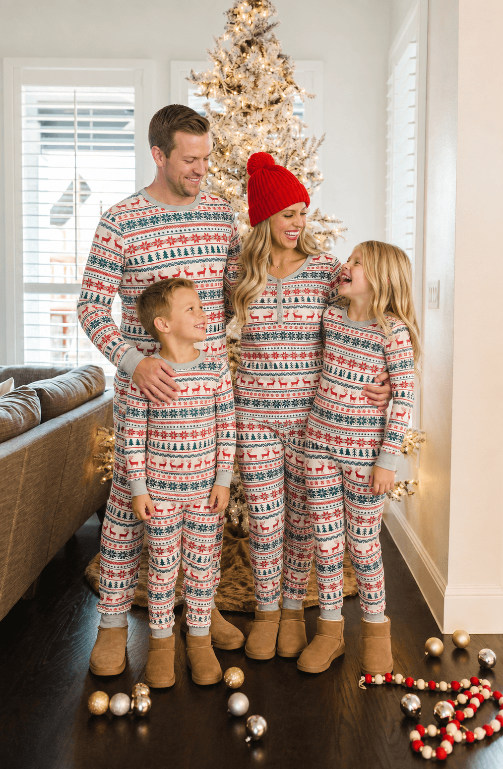 Family wearing matching reindeer print Christmas pajamas with gray ribbed cuffs