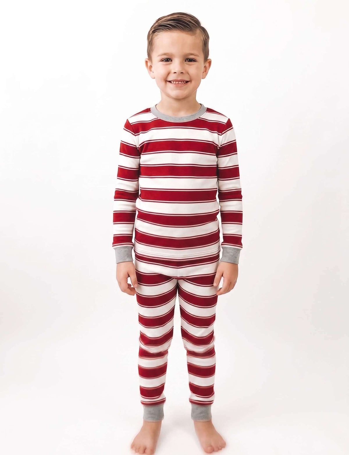 Family wearing matching red and white striped Christmas pajamas with gray trim - view 10