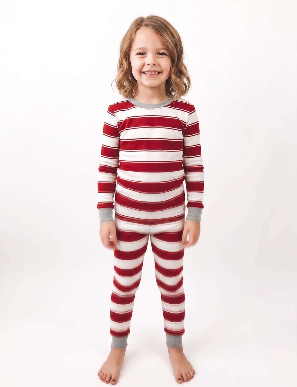 Family wearing matching red and white striped Christmas pajamas with gray trim - view 11