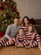 Family wearing matching red and white striped Christmas pajamas with gray trim - view 5